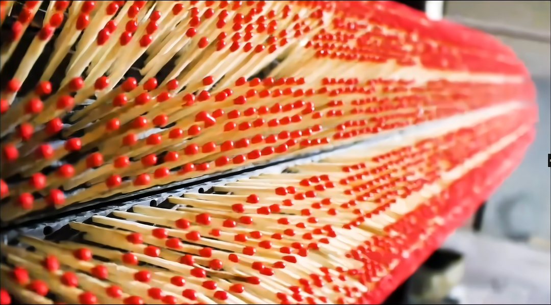 Rows of freshly dipped match sticks with red heads on the production rack